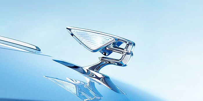 Romeo Ferraris SRL Bentley Flying Spur Azure sedan bonnet close up in Light Windsor Blue paint with Illuminated Flying B mascot